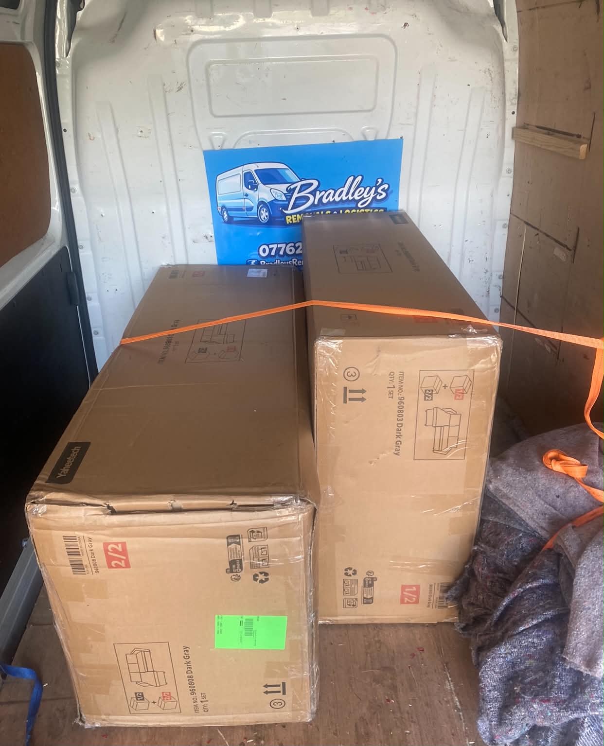Flat-pack furniture boxes strapped inside a Bradley's Removals & Logistics van