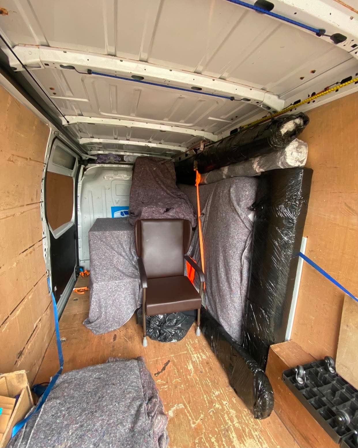 Armchair and furniture wrapped and secured inside a removal van